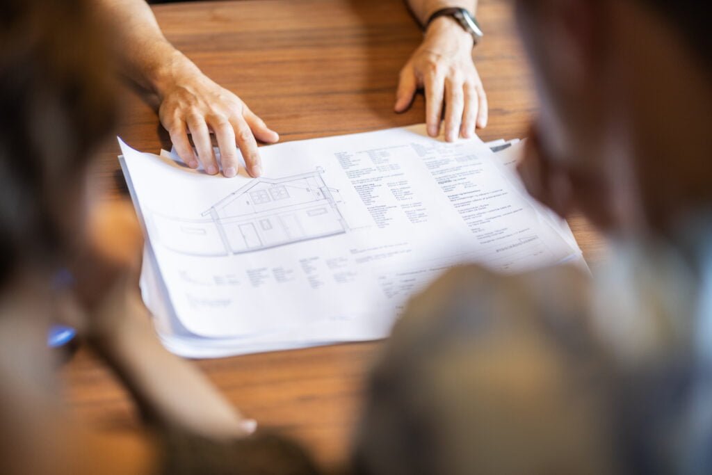 Arkitekt viser husplaner på bordet